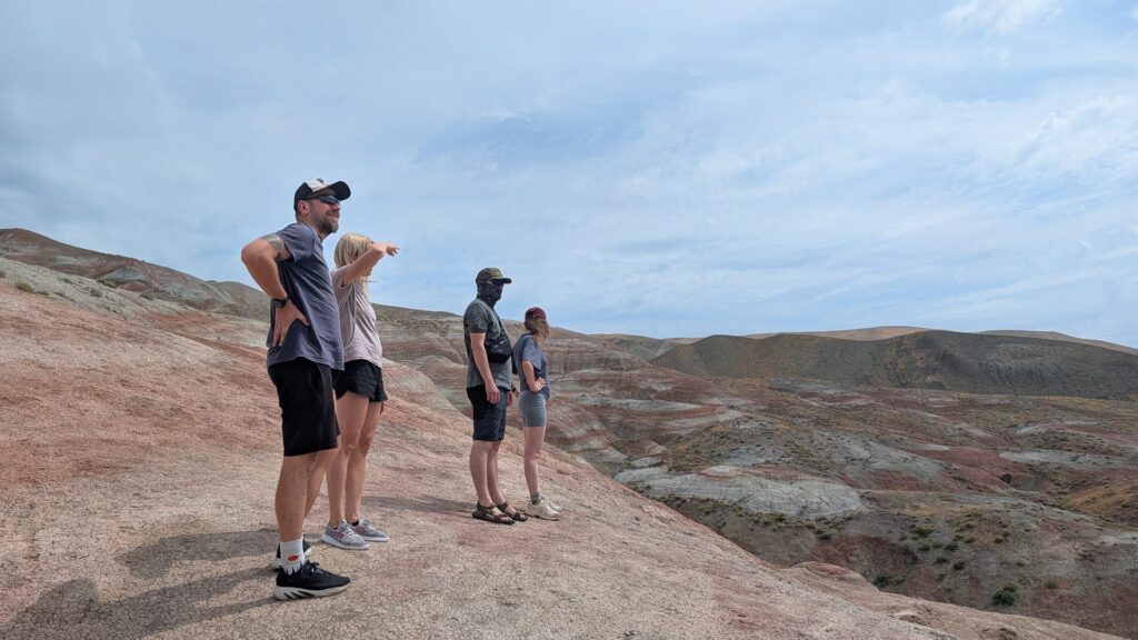 Four travellers looking out over the red and white striped Candy Cane Mountains