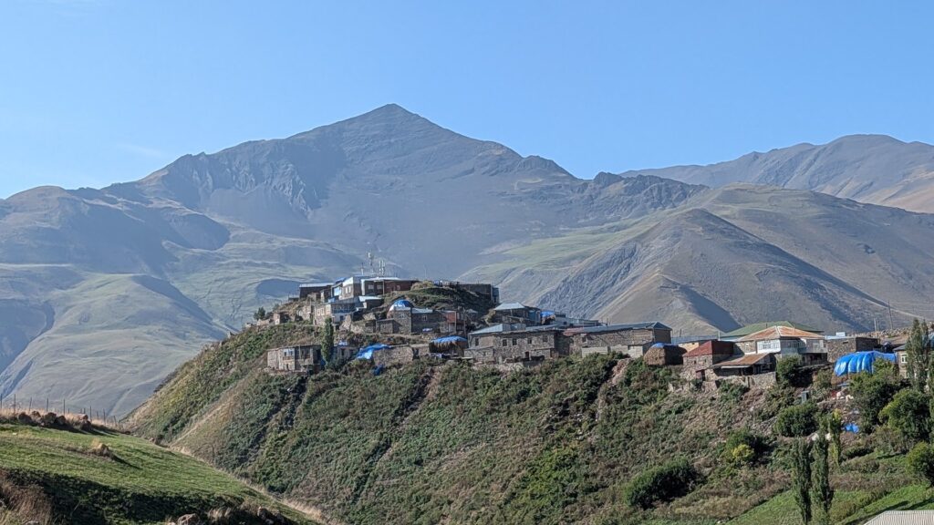 Khinalig village on its hilltop under the peaks of the Greater Caucasus