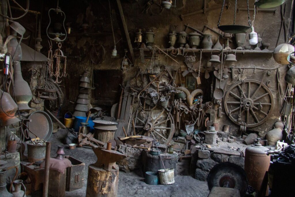 Inside a traditional coppersmith workshop in Lahij, full of copper pots, tools and old cart wheels