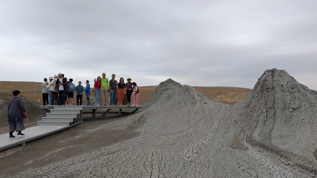 Hikers on the boardwalk among the mud volcano cones near Gobustan